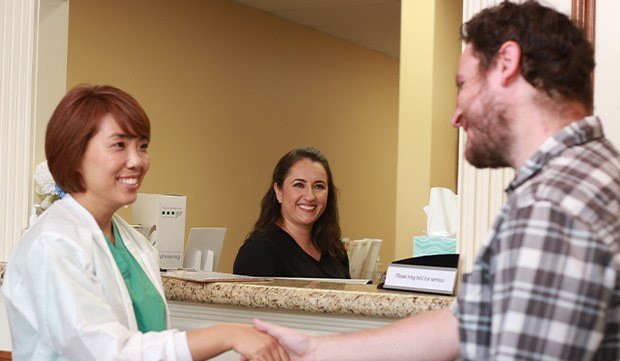 Dr. Kim shaking hands with dental patient