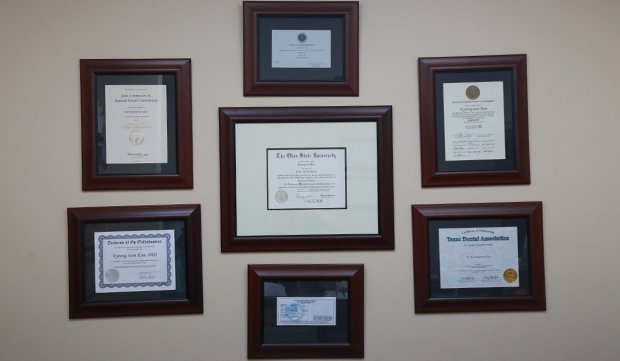 Dentist diplomas and certifications on wall