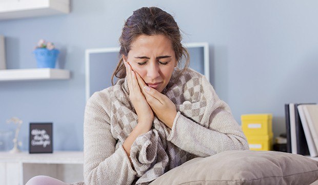 Woman in pain holding cheek