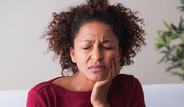 Woman in pain holding cheek