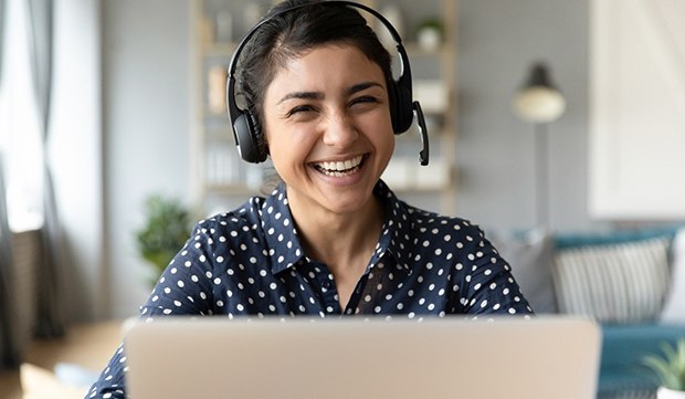 person with a headset on, smiling with their Invisalign trays in