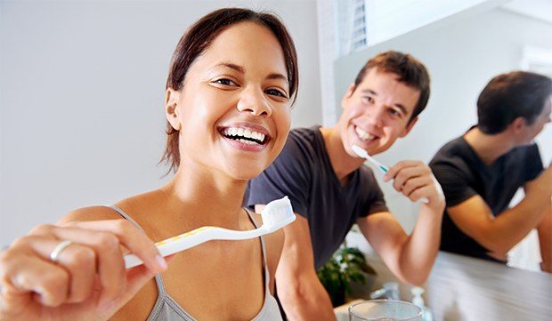 Man and woman brushing teeth