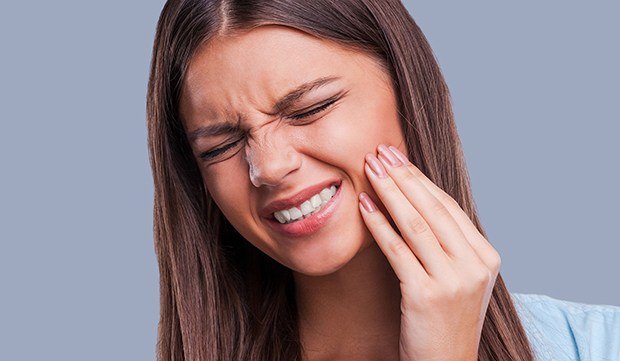 Woman holding jaw in pain